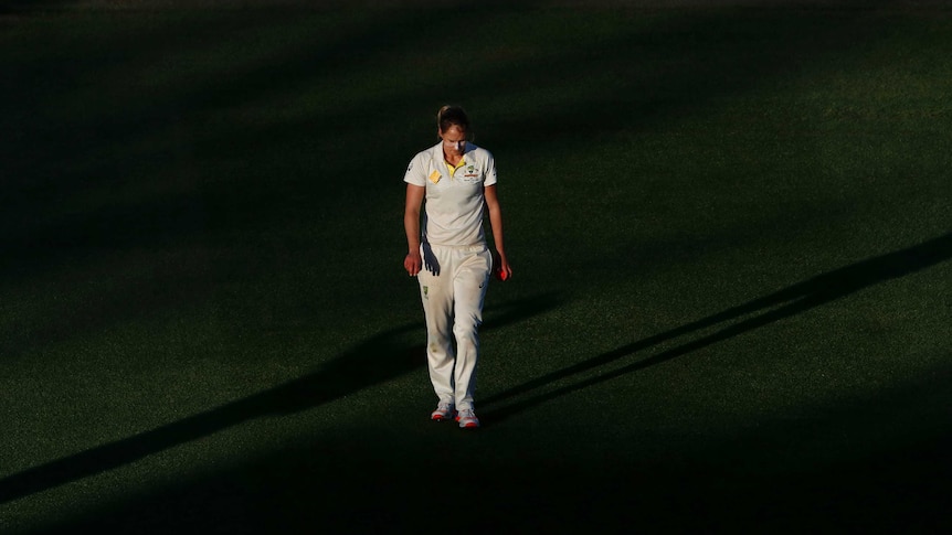 Ellyse Perry walking with her head down while holding a pink ball at North Sydney Oval.