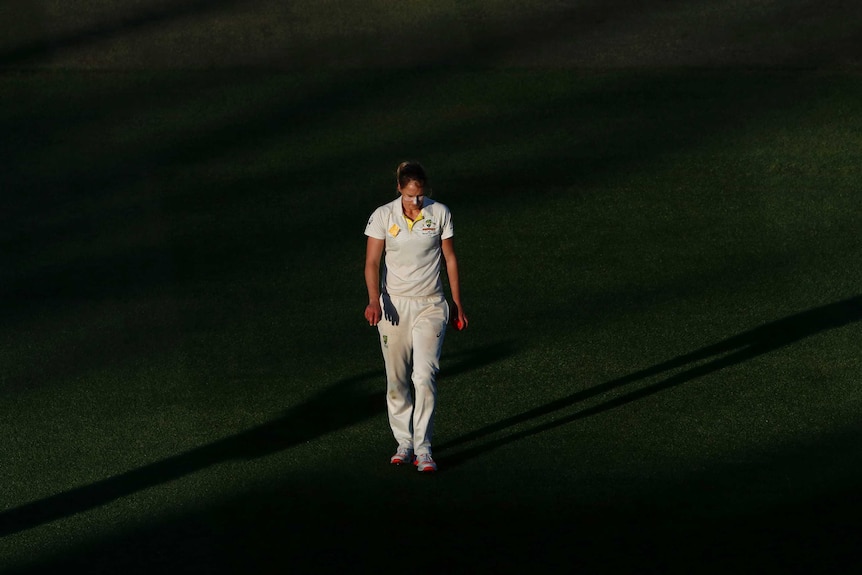 Ellyse Perry walking with her head down while holding a pink ball at North Sydney Oval.