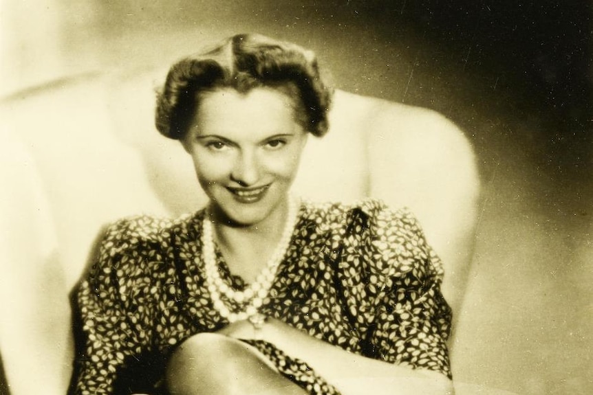 A black and white photo of a woman sitting on a chair 