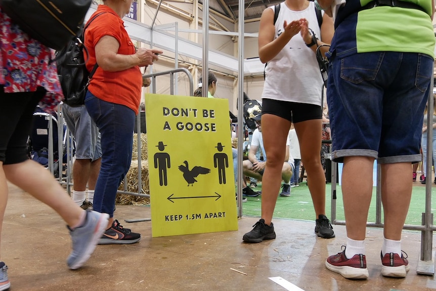 People standing around a social distancing sign at the Sydney Royal.