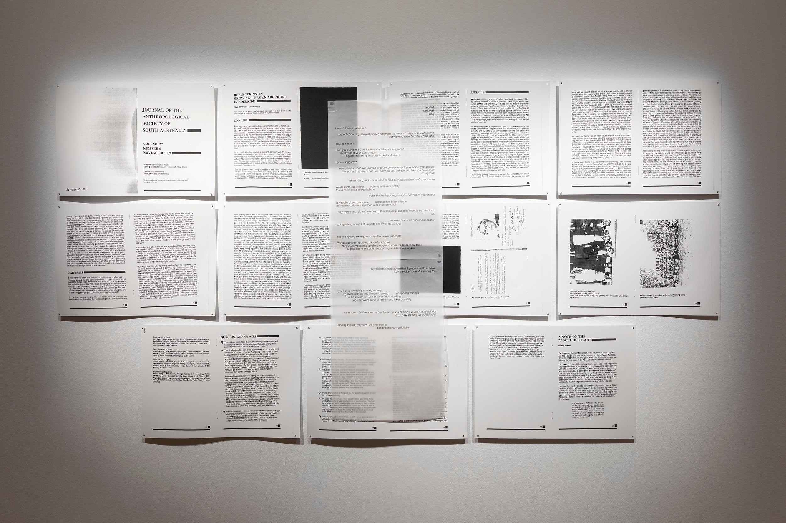 (un)silenced by Jayda Wilson featuring black and white printed sheets of paper arranged on a gallery wall.