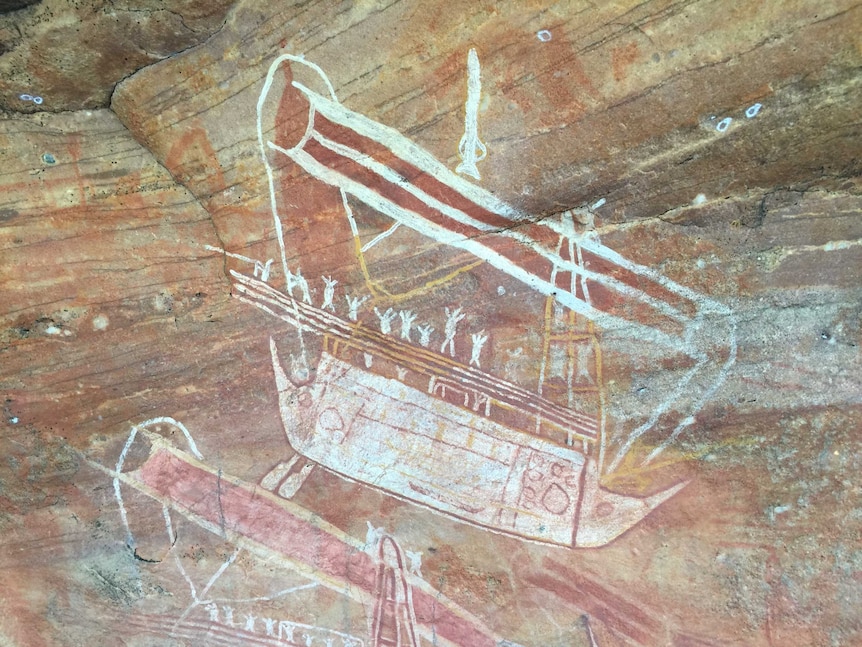 An ochre-coloured rock art painting of a boat carrying people.