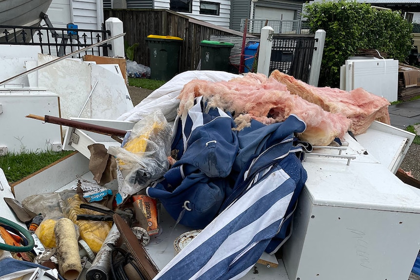Alli Lark's flood-ravaged possessions piled up outside her home at Deagon on Brisbane's northside after they were destroyed.