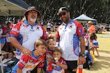 Two men and young boys pose for a photo.