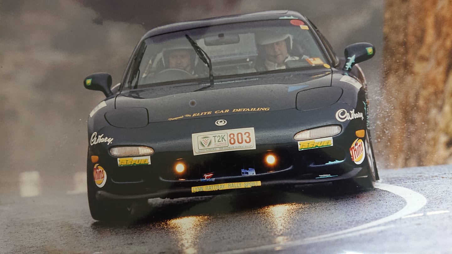 Two people drive fast in a sports car.