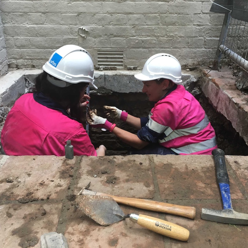 Archaeologists inspecting the footings of Harris Terrace