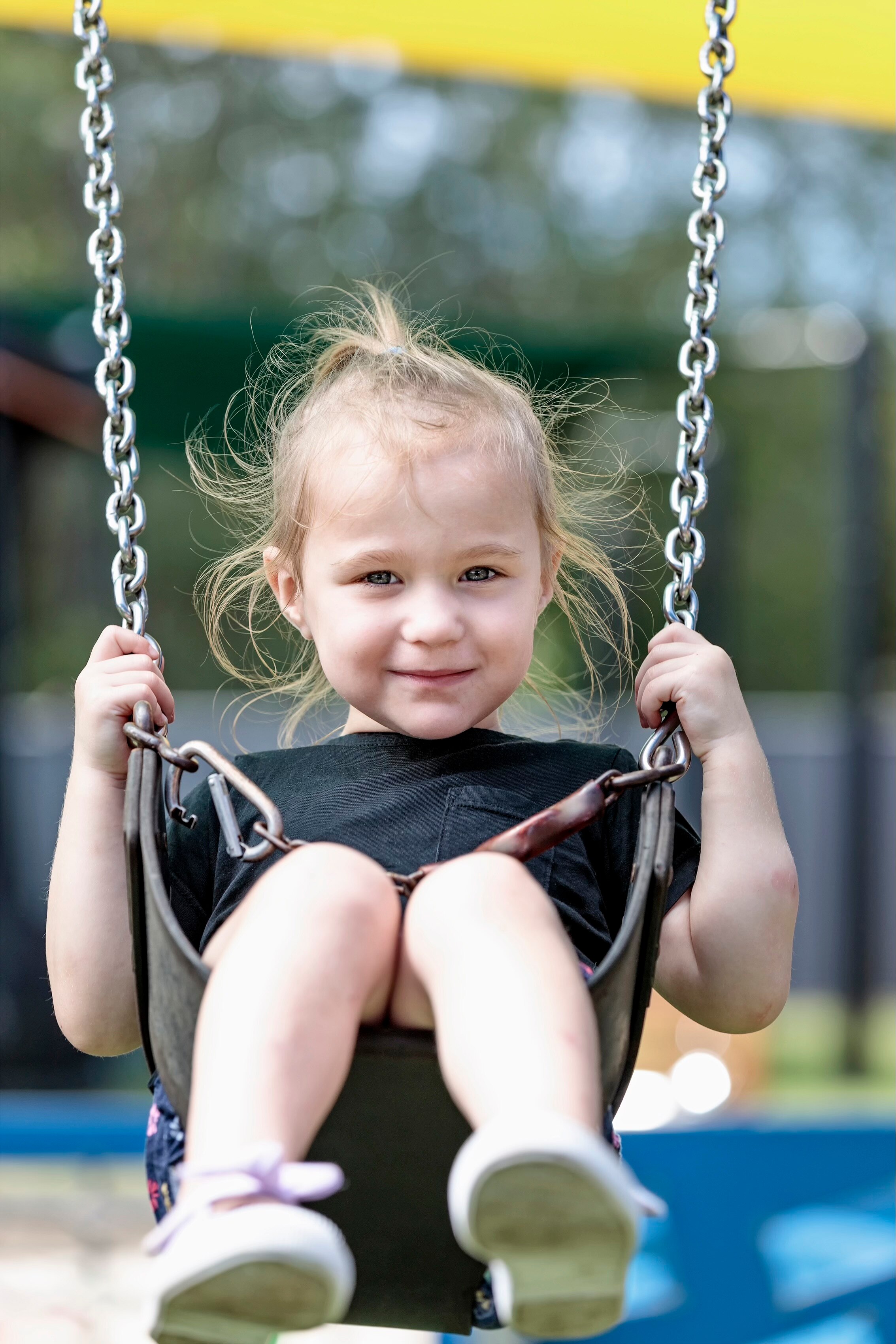 A three-year-old girl on a swing.
