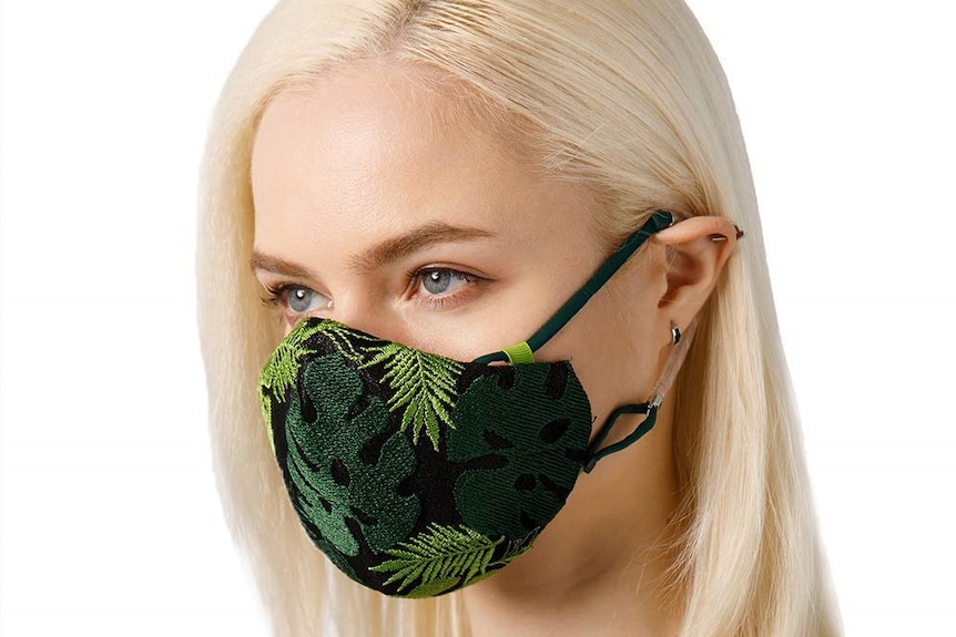 A blonde woman with a pollution mask on her face