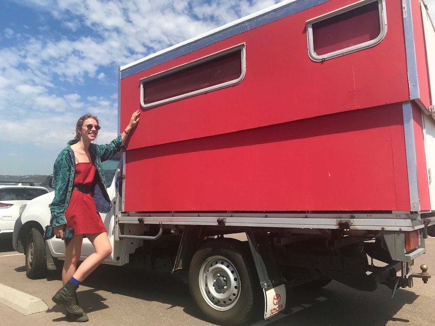 Ella Saul standing next to her utility with a red timber house on the tray.