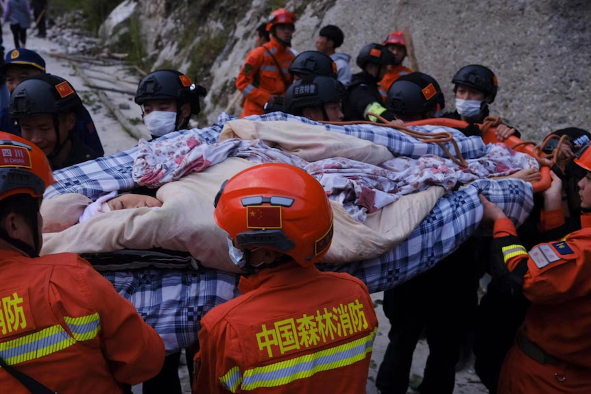 Rescuers transfer survivors from a town in south-west China's Sichuan Province. 