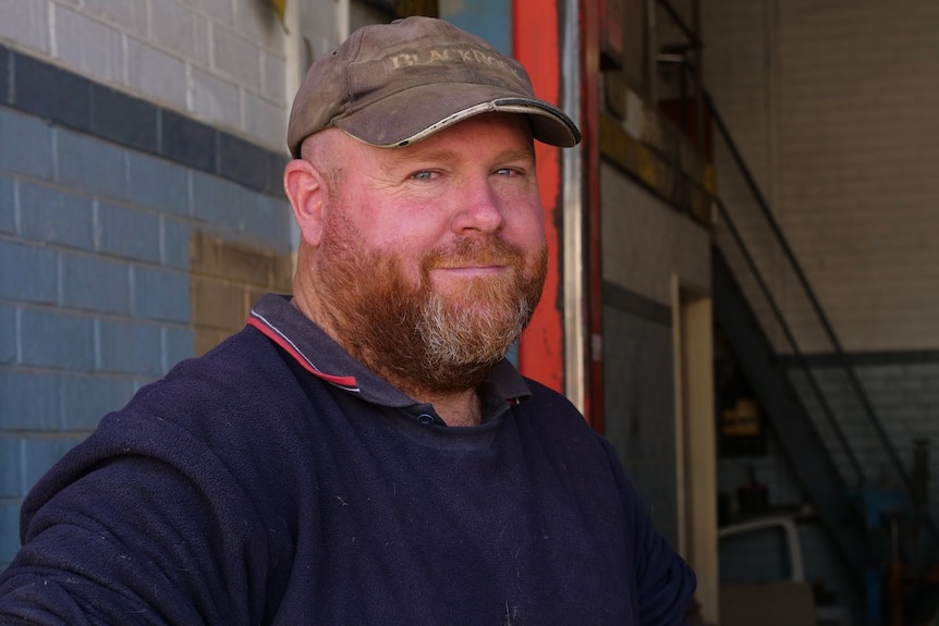 A close up of a man with a beard and a brown hat