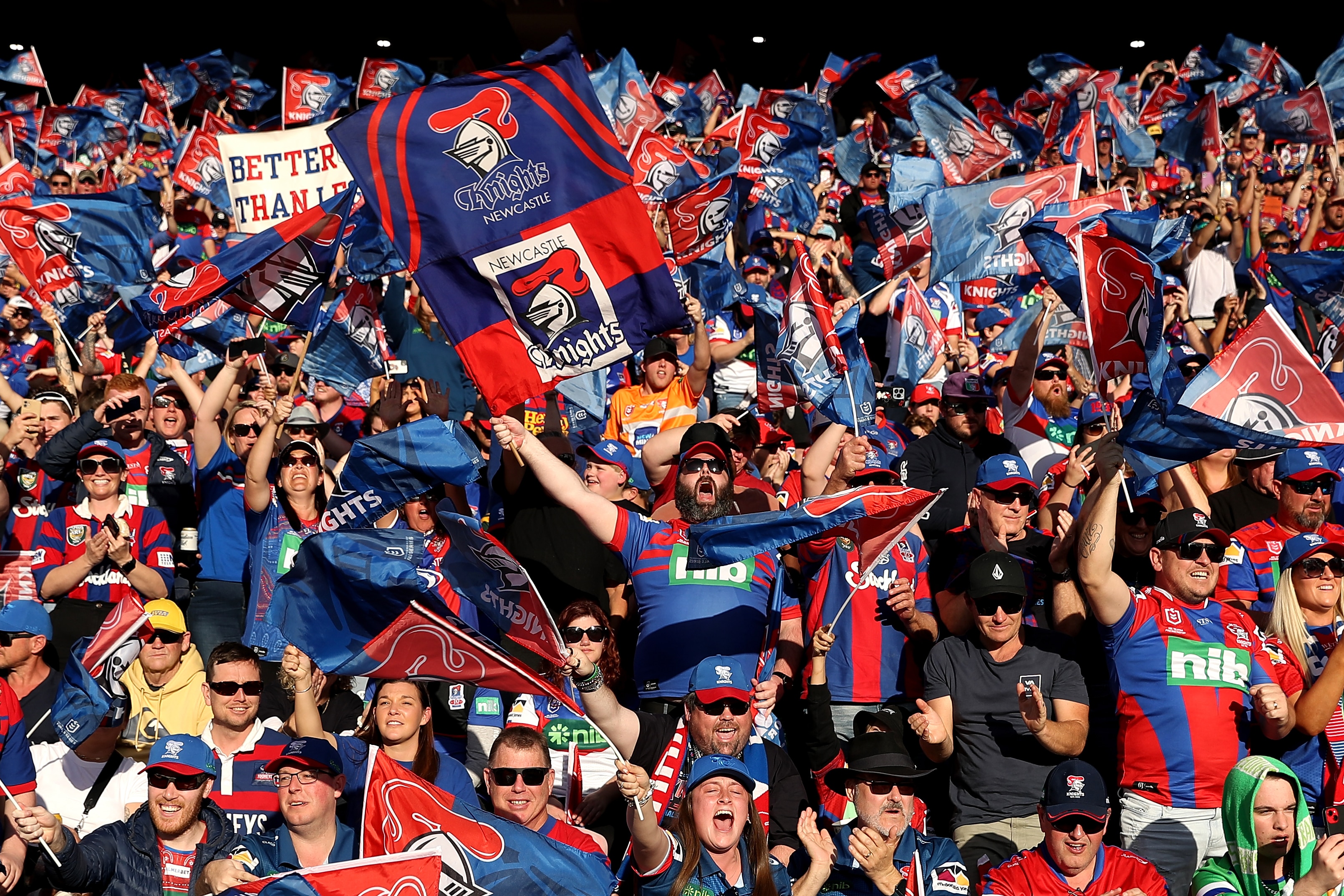 A group of fans celebrate a try in a rugby league match 