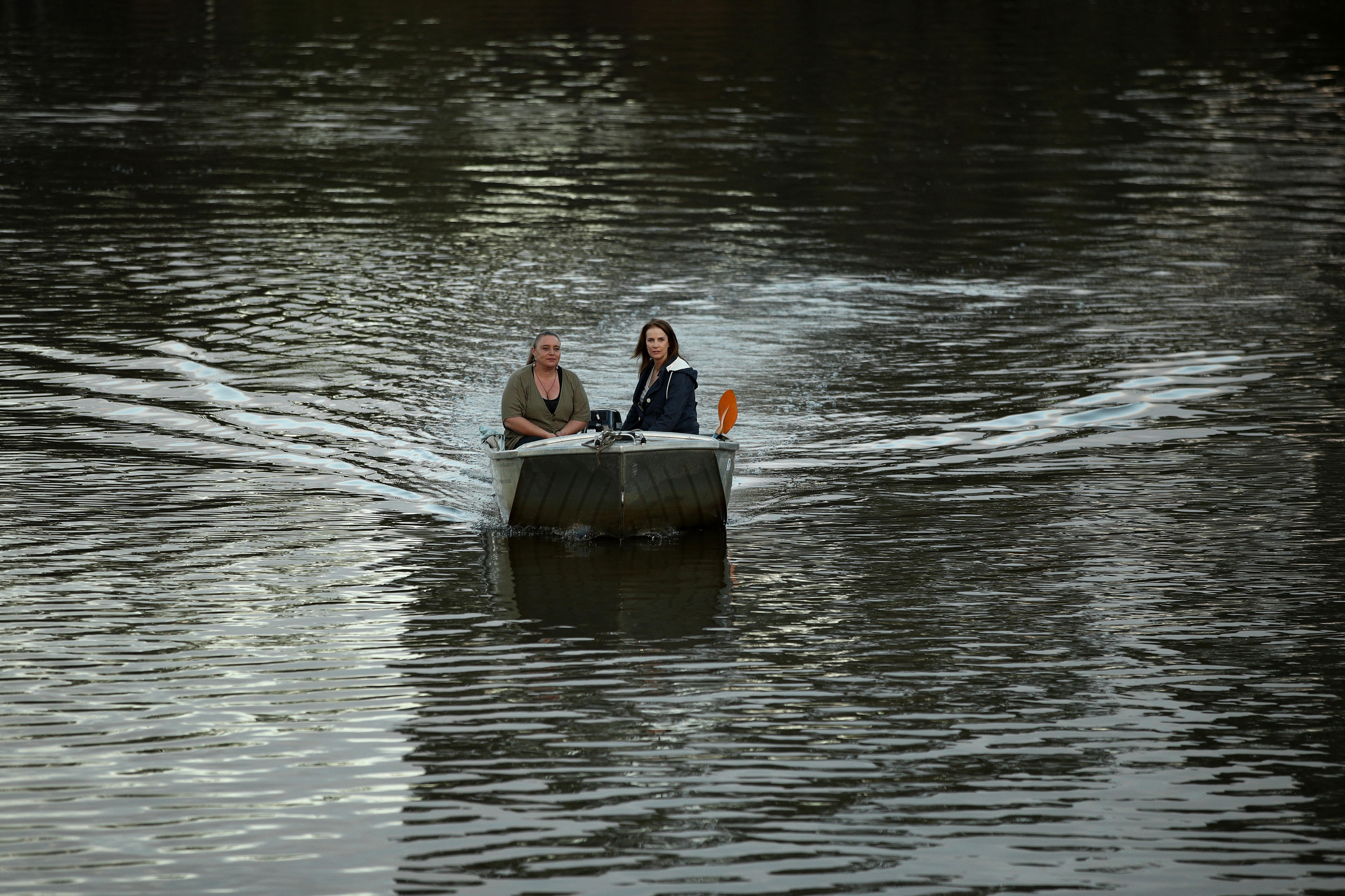 Rachel Griffiths sits in a boat with Erin Wilkins which is being driven down the Hawkesbury River. 