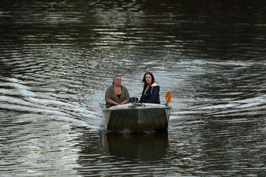 Rachel Griffiths sits in a boat with Erin Wilkins which is being driven down the Hawkesbury River. 