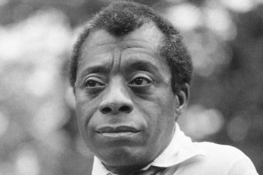 A black and white portrait of writer James Baldwin. 