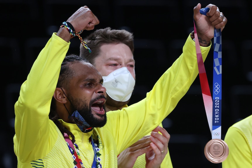 Patty Mills holds his Olympic bronze medal in his left hand.