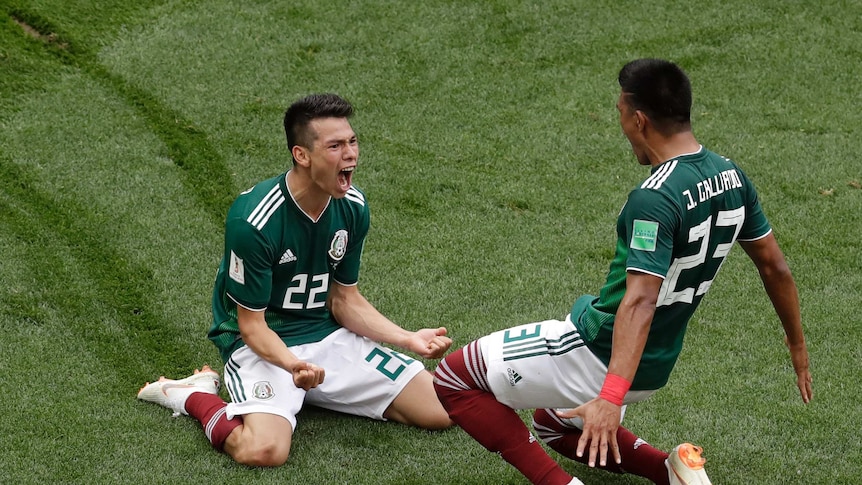 Mexico's Hirving Lozano slides along the grass on his knees after scoring