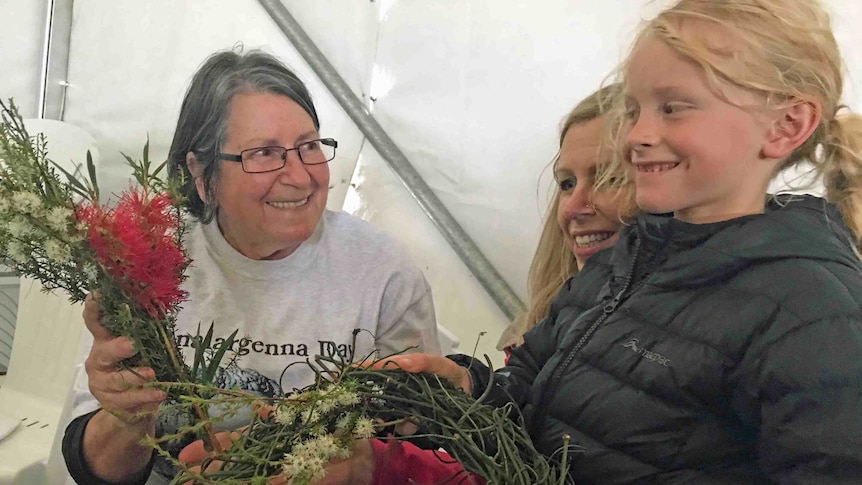 Aboriginal elder Patsy Cameron holds flowers