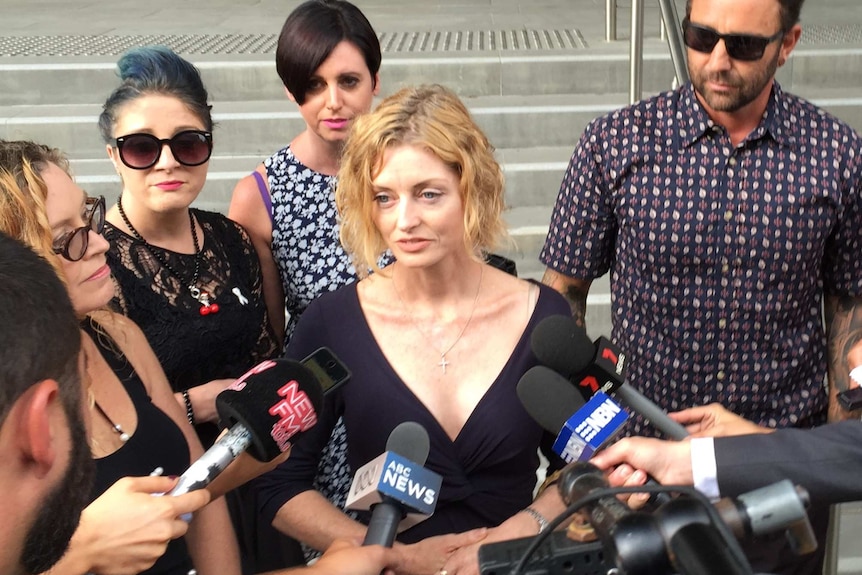 A woman speaks to the media outside court