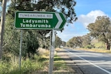 A green road sign that says 'Tumbarumba Road'