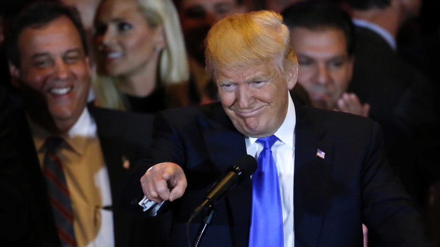 Donald Trump gestures as Chris Christie looks on