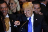 Donald Trump gestures as Chris Christie looks on