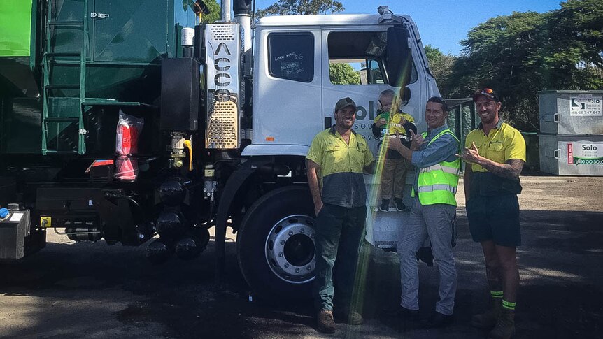 Men and boy standing with garbage truck