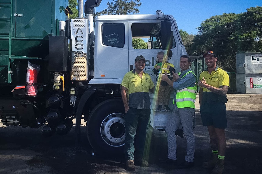 Men and boy standing with garbage truck