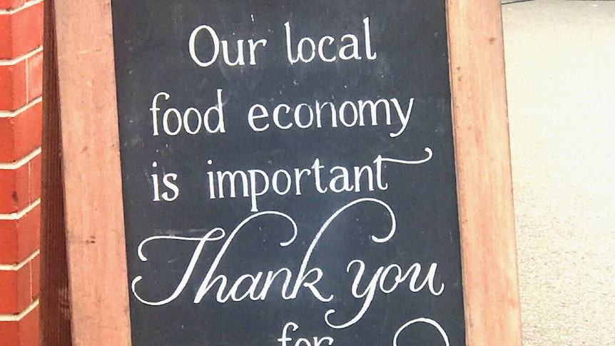 A sign at the Launceston Harvest Market reading 'Our local food economy is important. Thank you for your support.'