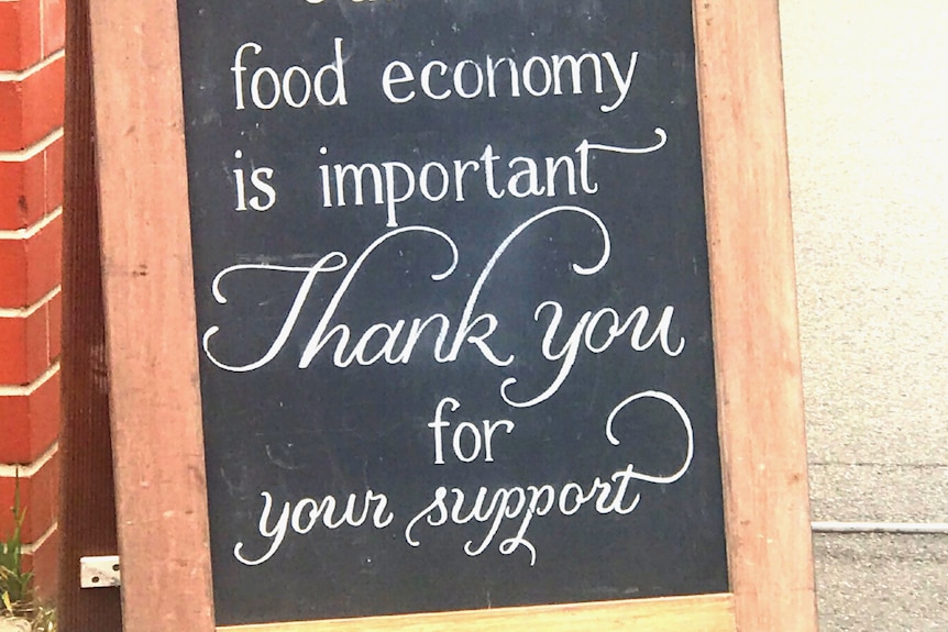 A sign at the Launceston Harvest Market reading 'Our local food economy is important. Thank you for your support.'