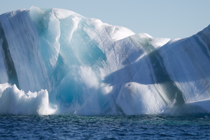 An iceberg showing dark stripes of seawater ice