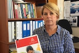 Kym Goodes from TasCoss holding budget priorities booklet.