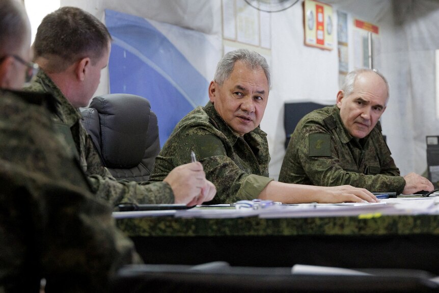 Russian Defence Minister Sergei Shoigu speaks to other soldiers in a staged photo.
