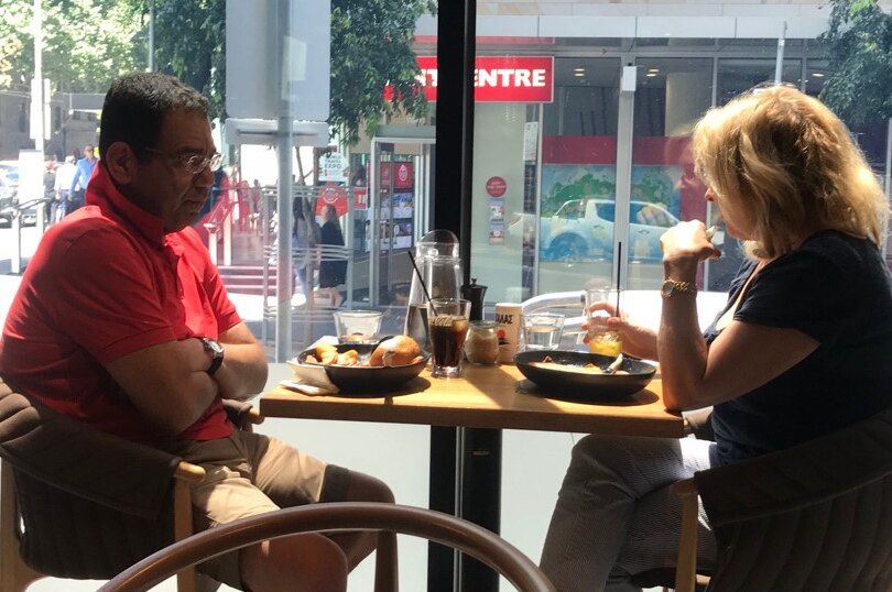 A picture of Sam Aziz and Lorraine Wreford sitting at a table in a cafe having lunch together.