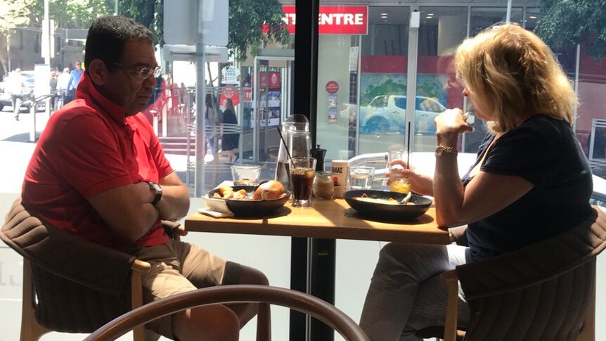 A picture of Sam Aziz and Lorraine Wreford sitting at a table in a cafe having lunch together.