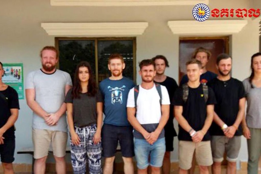 10 foreigners stand in a line in this photo released by Cambodian police