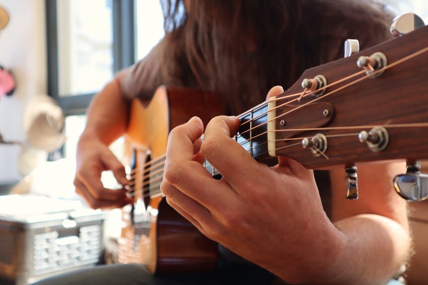 Close up of man playing guitar