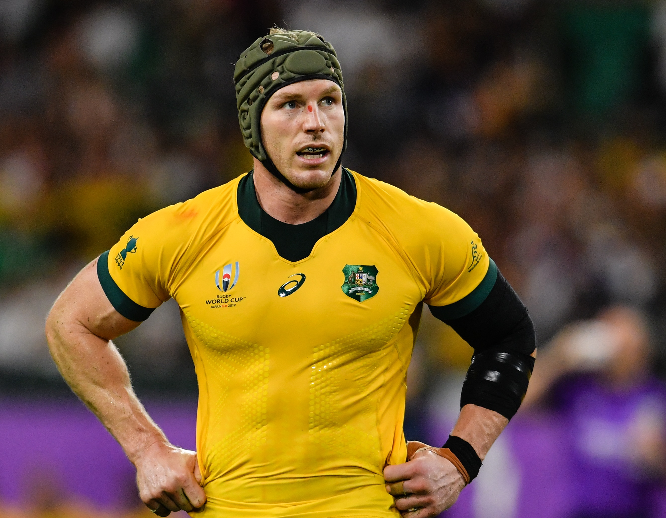 David Pocock, wearing a Wallabies jersey, puts his hands on his hips