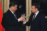 French President Emmanuel Macron, right, and Chinese President Xi Jinping share a toast during a state dinner
