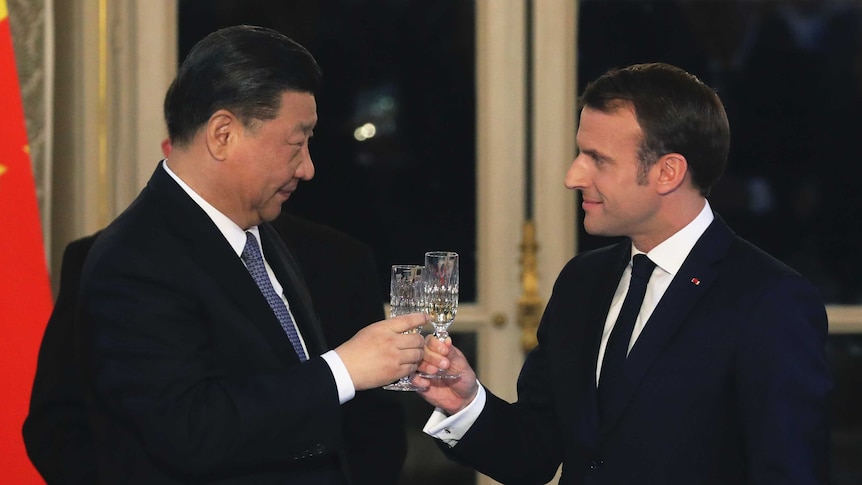 French President Emmanuel Macron, right, and Chinese President Xi Jinping share a toast during a state dinner