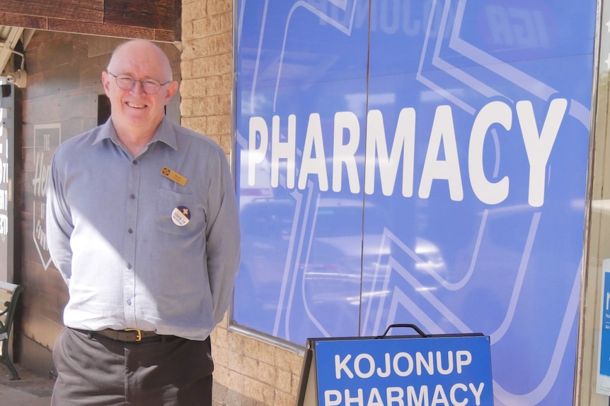 a man stands outside a pharmacy