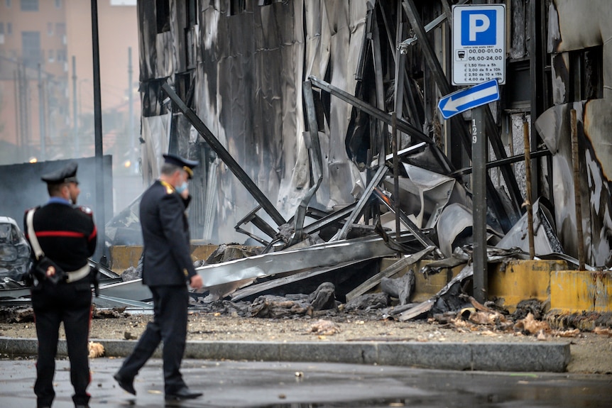 Carabinieri officers stand on the site of a plane crash