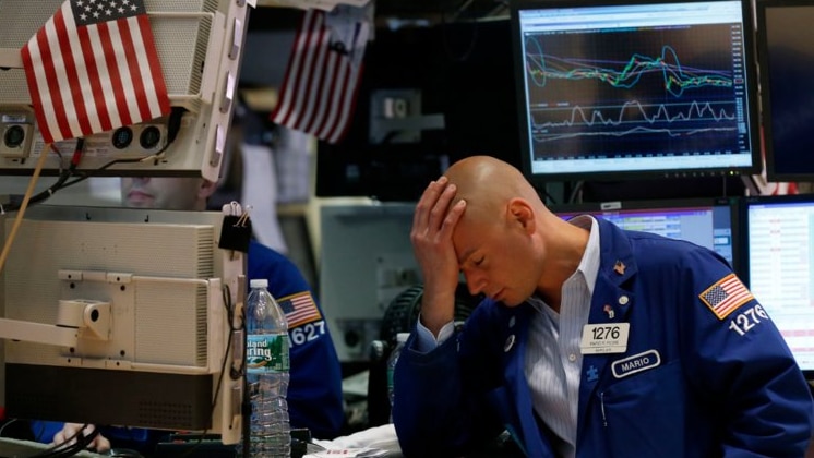 A Wall Street trader rests his head in his hand after a tough day