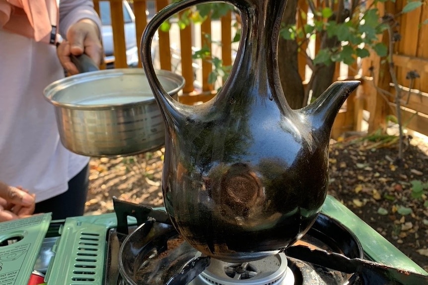 Boiling water to make coffee on a street stall.