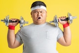 Asian man lifting weights against yellow background