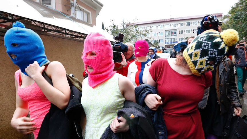 Masked members of the Russian band Pussy Riot leave police station