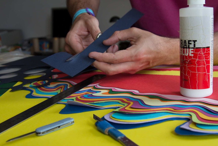 Benja Harney cutting paper at his Surry Hills studio