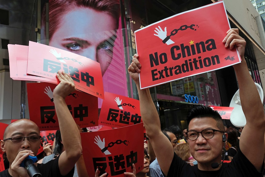 Demonstrators hold up red signs saying "no China extradition".