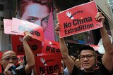 Demonstrators hold up red signs saying "no China extradition".