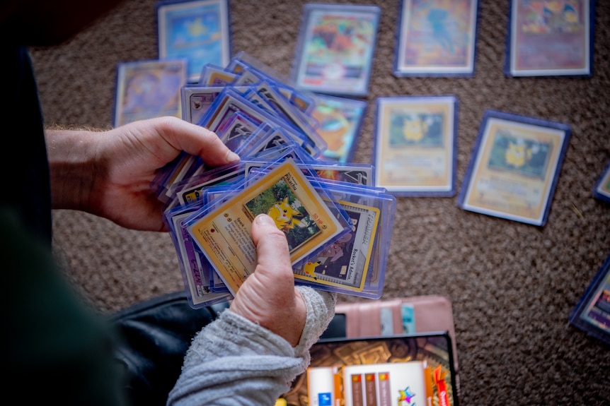 A hand holing Pokemon cards.